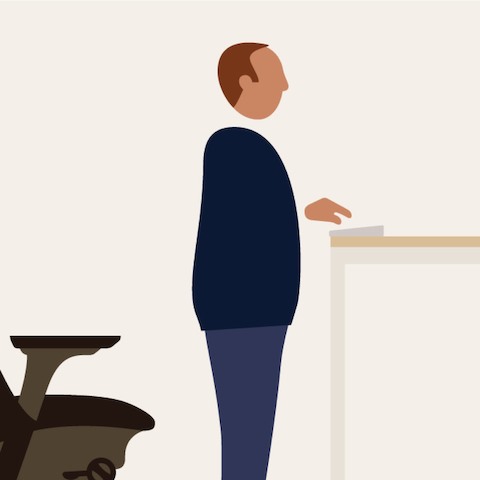 An illustration of a man standing between an office chair and a standing-height work surface.
