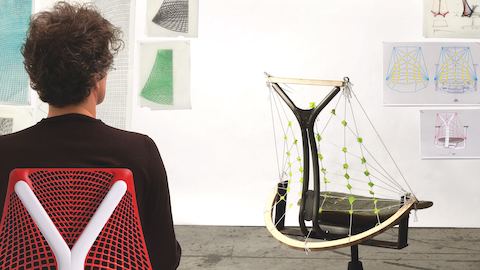 El diseñador Yves Béhar examina un modelo de la silla de oficina Sayl.