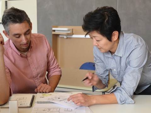 Product designers Cutter Hutton and Ayako Takase review a design drawing.