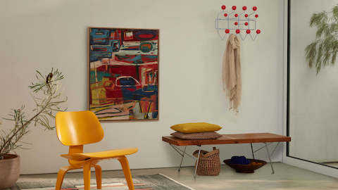 A modern entryway featuring vibrant new colourways for the Eames Hang-It-All and Moulded Plywood Lounge Chair.