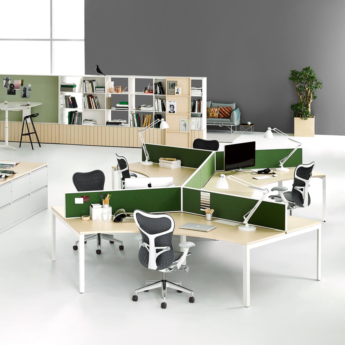 Werkplekken met groene privacyschermen en donkerblauwe Mirra 2 bureaustoelen.