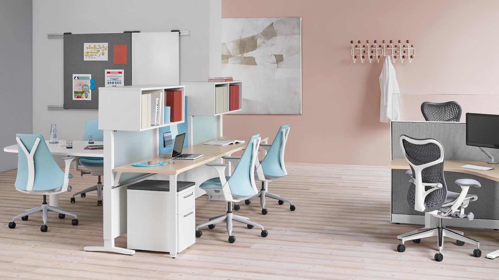 An open healthcare administrative area featuring light blue Sayl Chairs and grey Mirra 2 Chairs. Select to go to the Clinical products page.