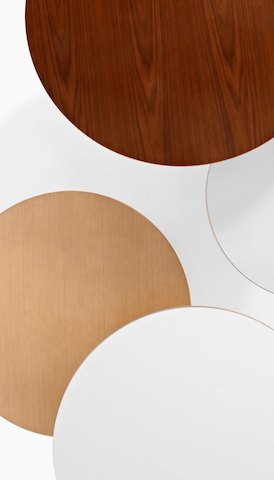 Vista aérea de cuatro mesas redondas superpuestas en varios acabados. Seleccione para ir a la página del producto Tables.