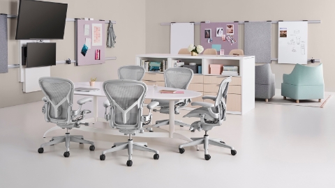 Light grey Aeron office chairs surround a table in a collaboration space.