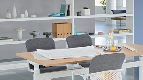 An open meeting space featuring a height-adjustable Atlas Office Landscape table and three grey Keyn chairs.
