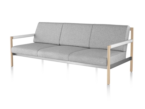 An angled view of a light gray Brabo sofa with wood legs and white arms.