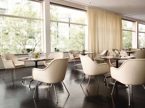 Dining environment featuring four-leg Bumper Chairs in tan fabric.