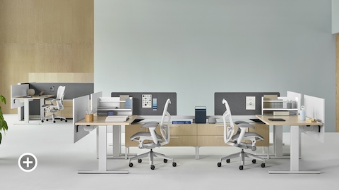 A Canvas Vista workstation with white Mirra 2 office chairs in the foreground and a Canvas Wall workstation with white Mirra 2 office chairs in the background. Select to go to the Canvas Lookbook landing page.