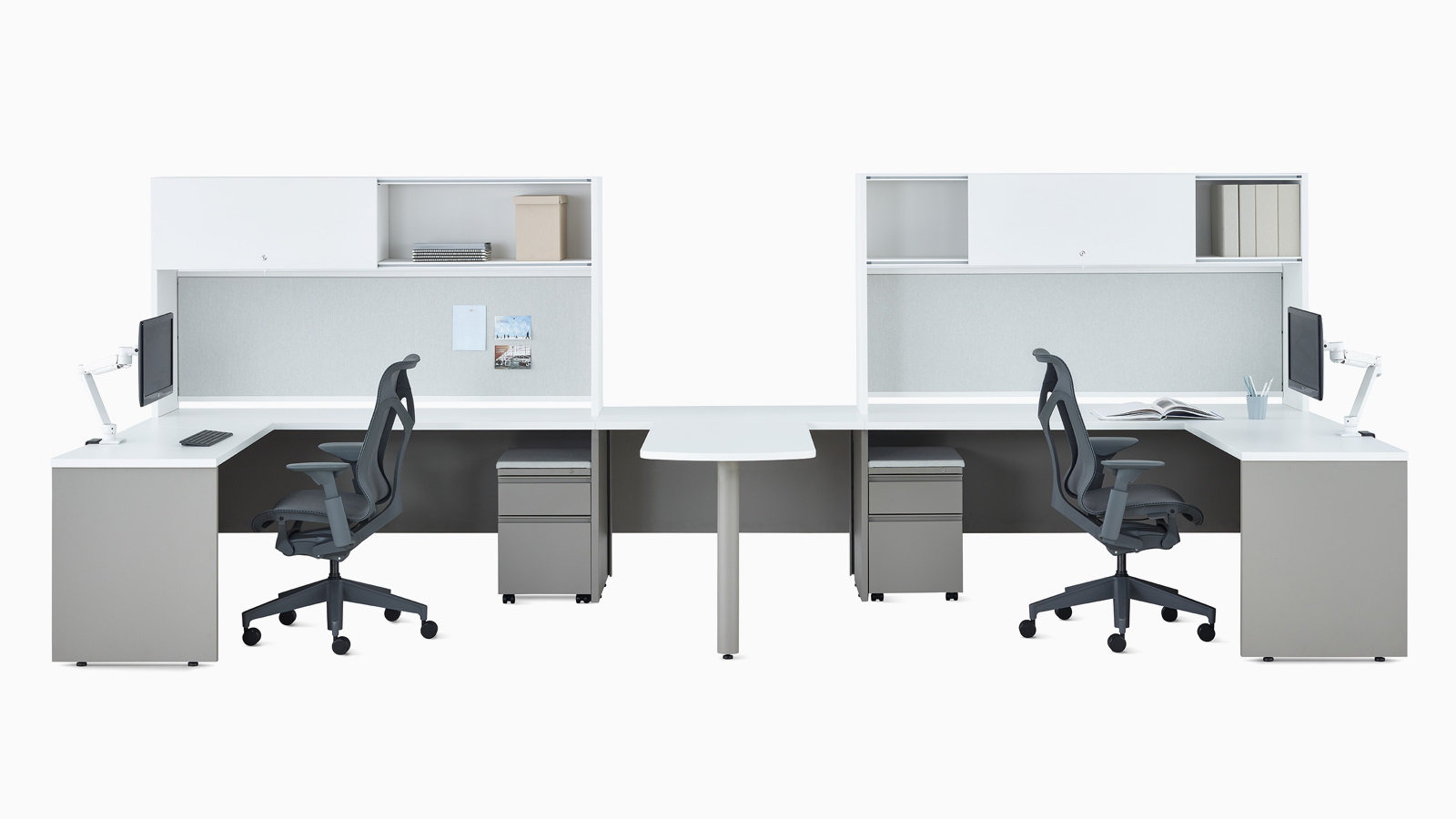 Dos escritorios metálicos Canvas en blanco y gris con almacenamiento superior, brazos articulados para monitor Concerto y sillas Cosm en gris oscuro.