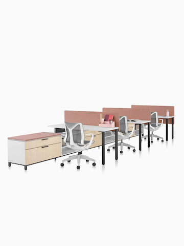 Una estación de trabajo Canvas Storage con superficies blancas, pantallas rosa y sillas para oficinas Cosm grises. Seleccione para ir a la página del producto Canvas Storage.