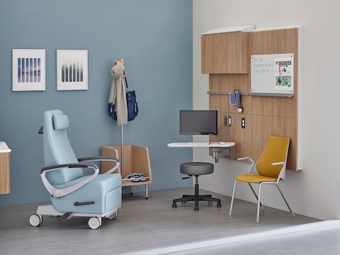 Un paciente reclinable, una silla lateral y un taburete en una sala de examen.