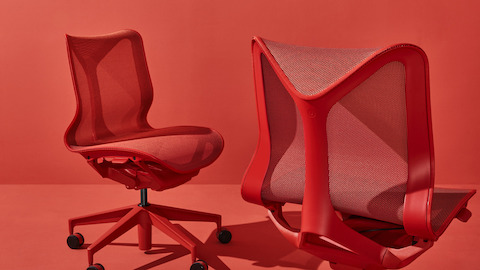 Two armless low-back Cosm Chairs in Canyon red on a red background. Select to go to the Cosm Chairs product page.