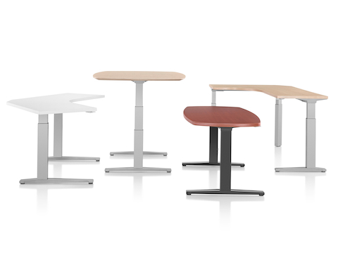 Cuatro mesas Renew Sit-to-Stand de varias formas y colores superiores.