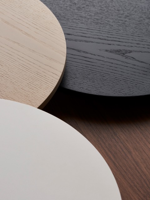 Overhead view of three overlapping round table tops in white, tan, and black.