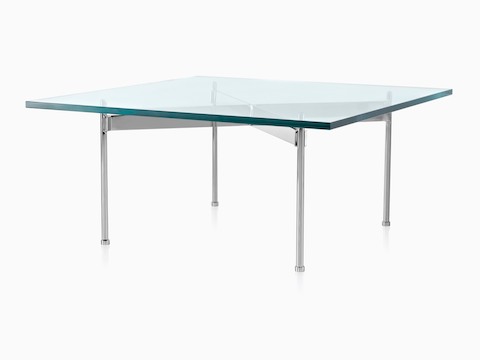An angled view of a glass-top Claw Table with a rectangular surface and four metal legs. 