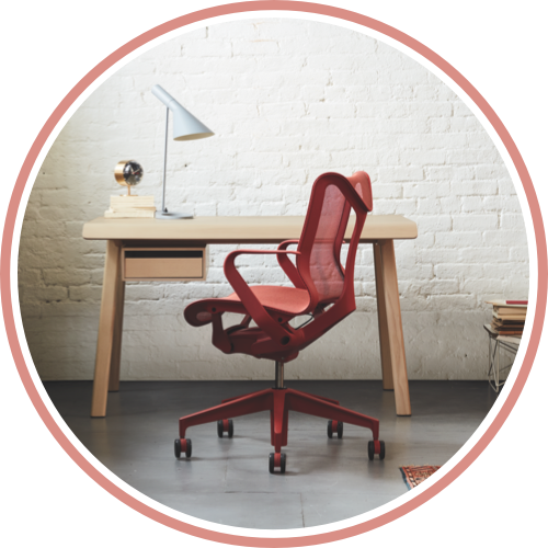 A small office with a Canyon red Cosm low-back chair in front of a Distil desk in ash. Select to start shopping for Cosm for your home or small business.