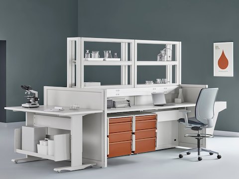 Soft white Co/Struc System with terra cotta storage drawers, various laboratory equipment, and a process table with a dark gray Verus Stool.