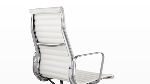 Vista trasera de tres cuartos de una silla Eames Aluminum Group con respaldo alto blanco.