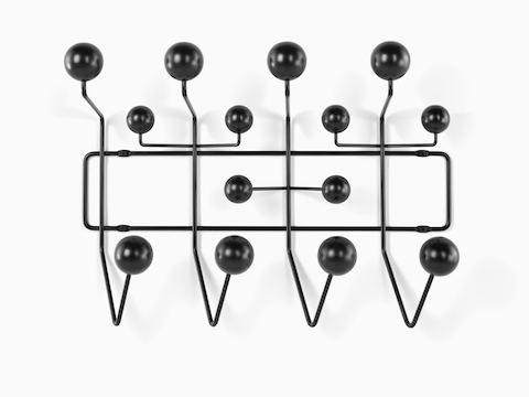 An Eames Hang-It-All storage rack, featuring a black wire frame and black wood knobs.
