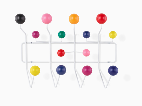 An Eames Hang-It-All storage rack, featuring a white wire frame and multicoloured wood knobs.