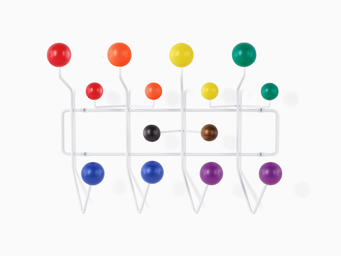 An Eames Pride Hang-It-All, showing a white wire frame and rainbow-coloured knobs