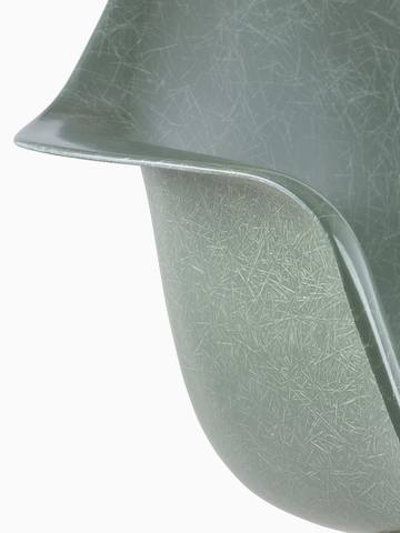 Primer plano de la carcasa de una silla de fibra de vidrio moldeada Eames en verde oscuro.