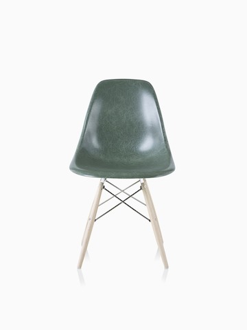Una silla de visita de fibra de vidrio moldeada Eames con base de clavijas de soporte y asiento en verde oscuro.