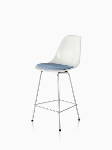 White Eames Molded Fiberglasss Stool with a light blue seat pad, viewed from a 45-degree angle.  