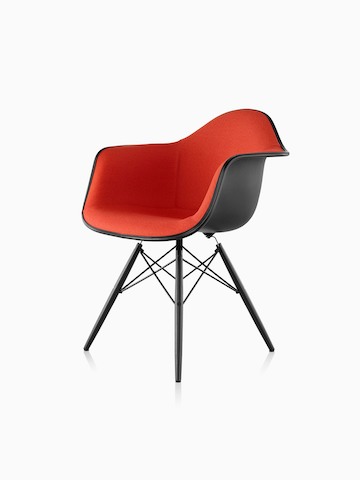 Red upholstered Eames Molded Plastic armchair with dowel legs, viewed from a 45-degree angle.