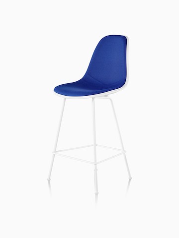 White Eames Molded Plastic Stool with blue upholstery, viewed from a 45-degree angle. 