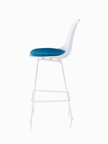 Profile view of a white Eames Molded Plastic Stool with a blue seat pad. 