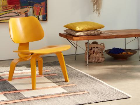 An Eames Moulded Plywood Chair and Nelson Platform Bench with metal legs.