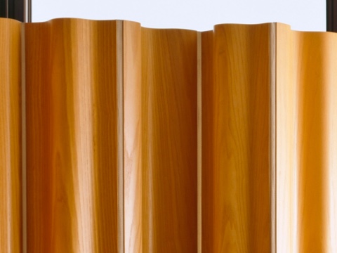 The upper portion of an Eames Molded Plywood Folding Screen in a medium wood finish.