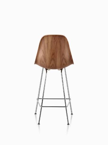 Eames Molded Wood Stool with a medium finish and silver legs, viewed from the rear. 