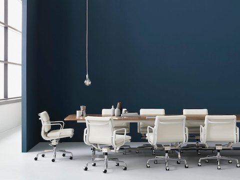 White leather Eames Soft Pad Chairs around a rectangular conference table.