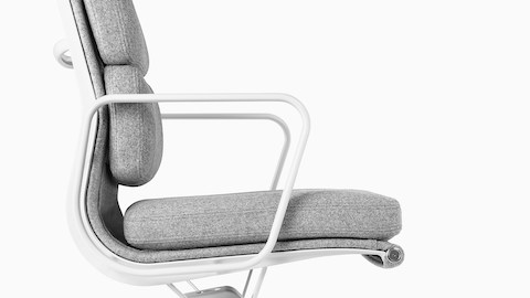 Profile view of a light gray upholstered Eames Soft Pad Chair.