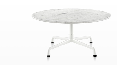 Una mesa redonda de Eames con una tapa de mármol blanco.