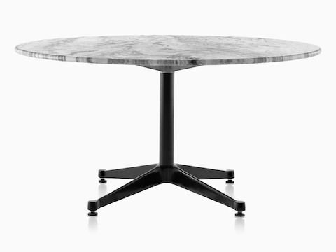 Una mesa redonda Eames al aire libre con una tapa de mármol gris y una base negra.