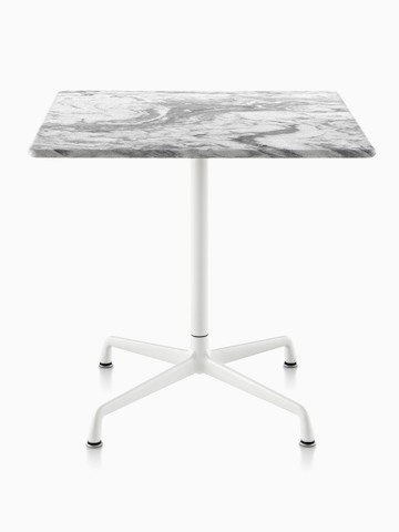 Una mesa cuadrada Eames al aire libre con una tapa de mármol gris y base blanca.