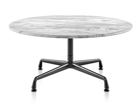 Una ronda Eames mesa al aire libre con una tapa de mármol blanco y base negra.