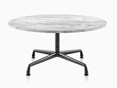 Una ronda Eames mesa al aire libre con una tapa de mármol blanco y base negra.
