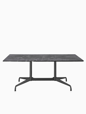 Una mesa rectangular Eames al aire libre con una tapa de piedra negra.