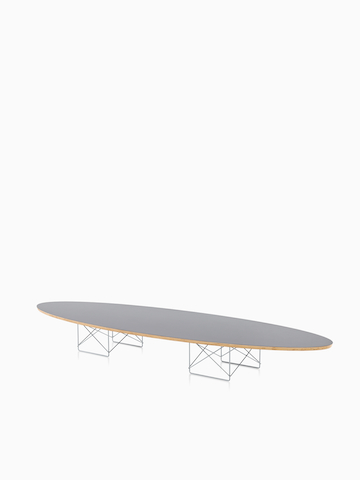 Una mesa elíptica de base de alambre Eames con una parte superior gris. Seleccione para ir a la página del producto Eames Wire Base Elliptical Table.