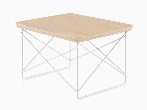 Vista en ángulo de una mesa baja con base de cables Eames con una parte superior de chapa de fresno blanco.
