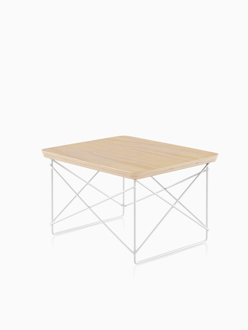 Una mesa baja de base rectangular de Eames con un acabado de madera clara. Seleccione para ir a la página del producto Eames Wire Base Low Table.