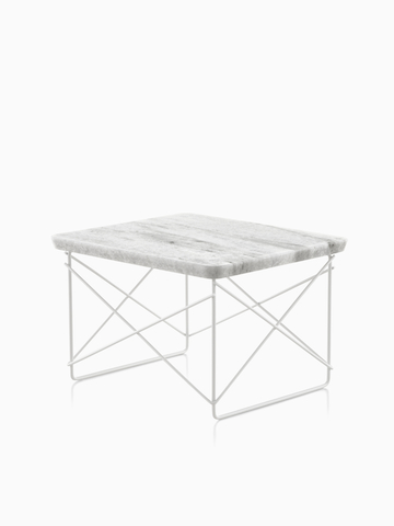 An Eames Wire Base low outdoor table with a stone top. select to go to the Eames Wire Base Low Table Outdoor product page.