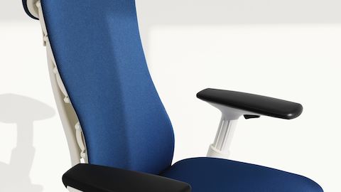 Control de altura del brazo en una silla Embody con tapizado azul y un marco blanco.