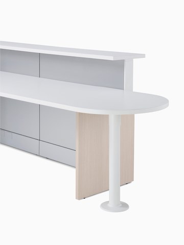 Detail of Ethospace in a light wood finish featuring a round-end ADA peninsula surface, white transaction top, and light gray panels.