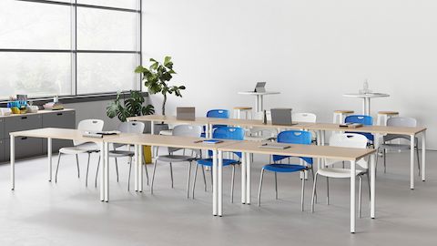 A learning environment featuring two rows of Everywhere Tables and Caper stacking chairs in various colours.