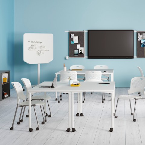 Everywhere Tables in a learning environment, including rectangular and round standing height options with white Caper Stacking Chairs.